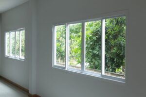 White walls and white-framed sliding windows in rows of four are shown from the inside of a room